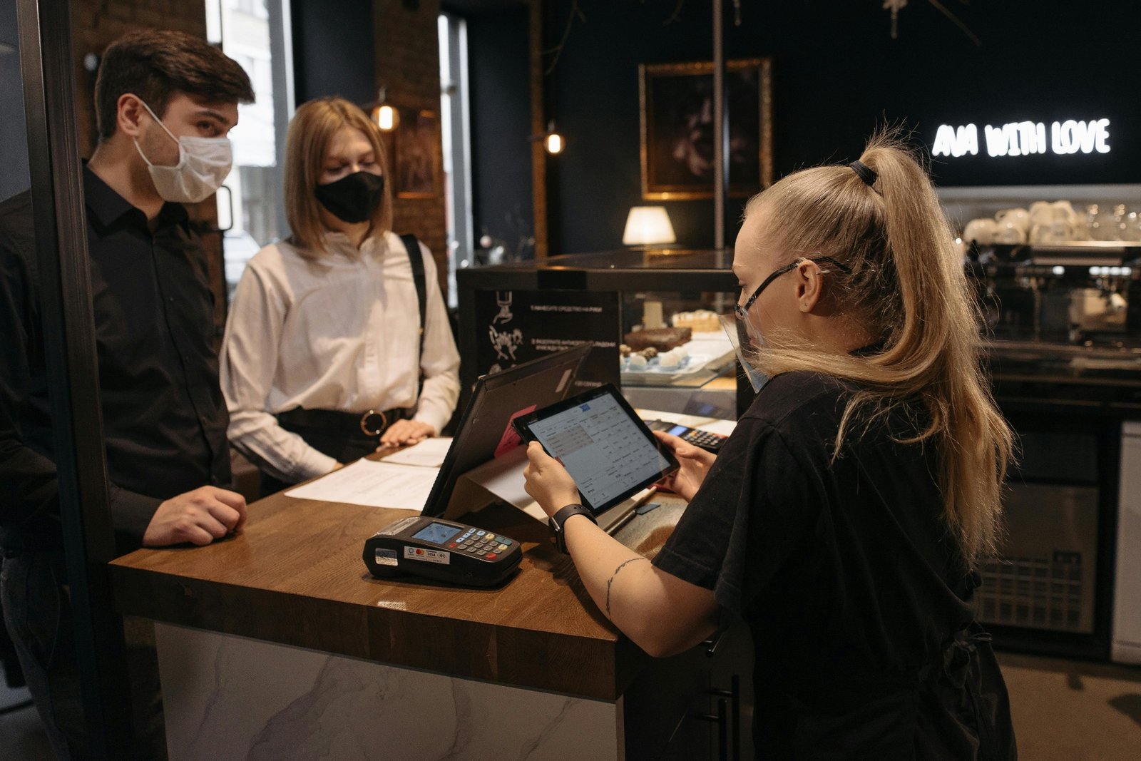 Restaurant staff member taking a call at a busy front desk