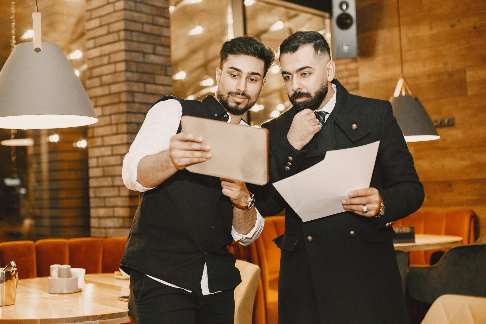 Two restaurant managers reviewing performance on a tablet