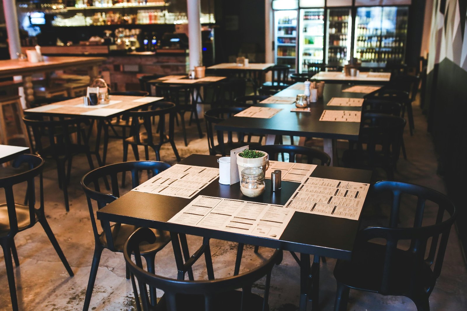 Empty restaurant dining room with menus on tables before service begins