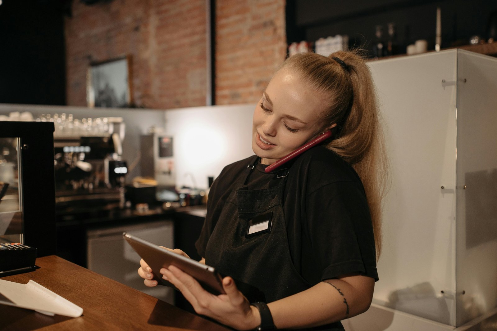 Restaurant host station with a phone on the counter and a busy dining room in the background