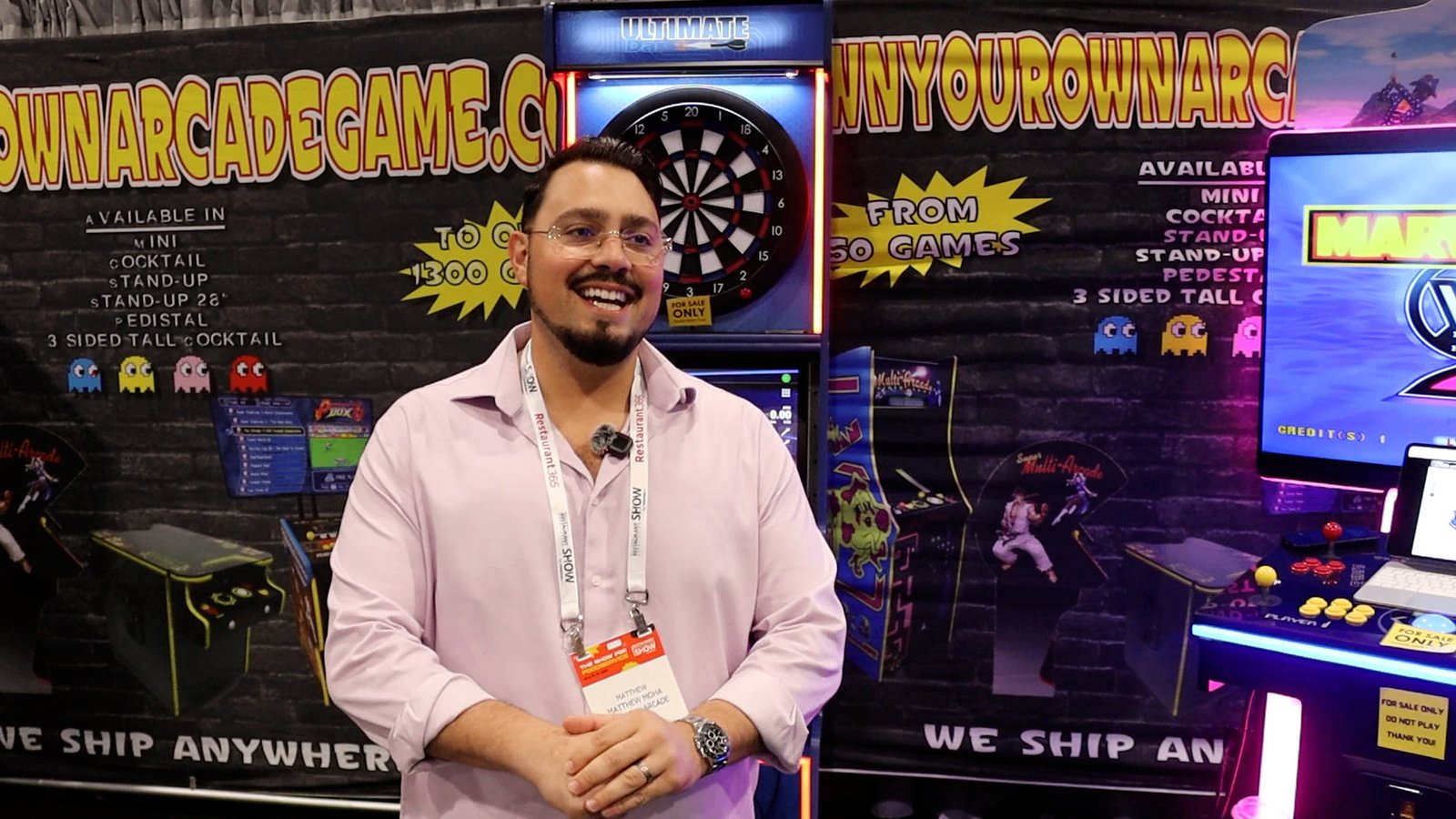 Matthew Moha from American Arcade speaking in front of arcade machines at the National Restaurant Association Show