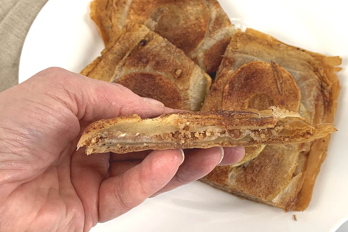 Apple pecan phyllo crisp cut and one piece in hand to show the layers.