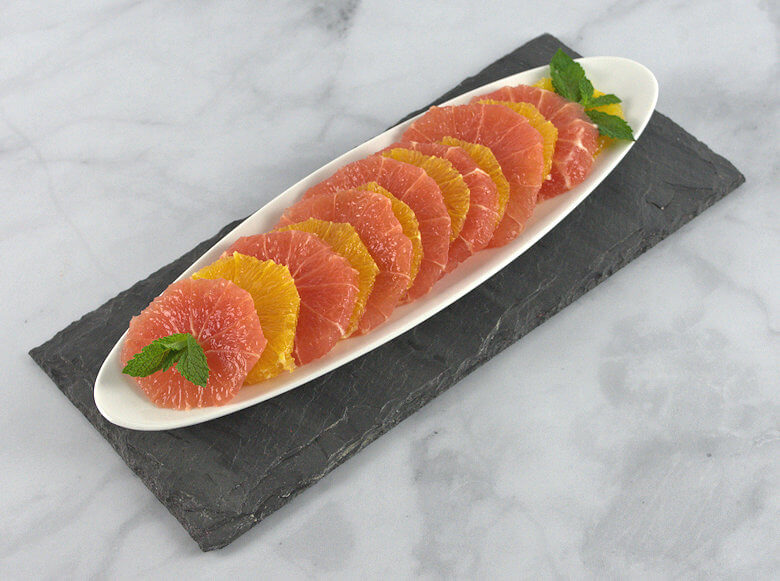 Slices of grapefruit and oranges decorated on a white dish