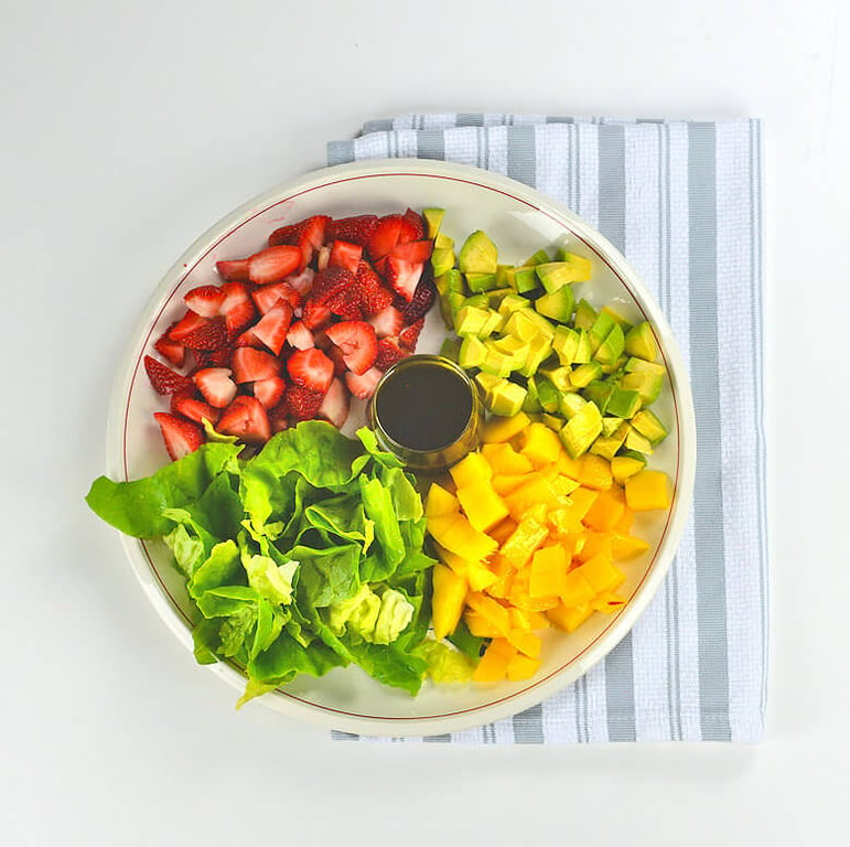 Picture of cut ingredients of fruit salad with dressing in separate bowl