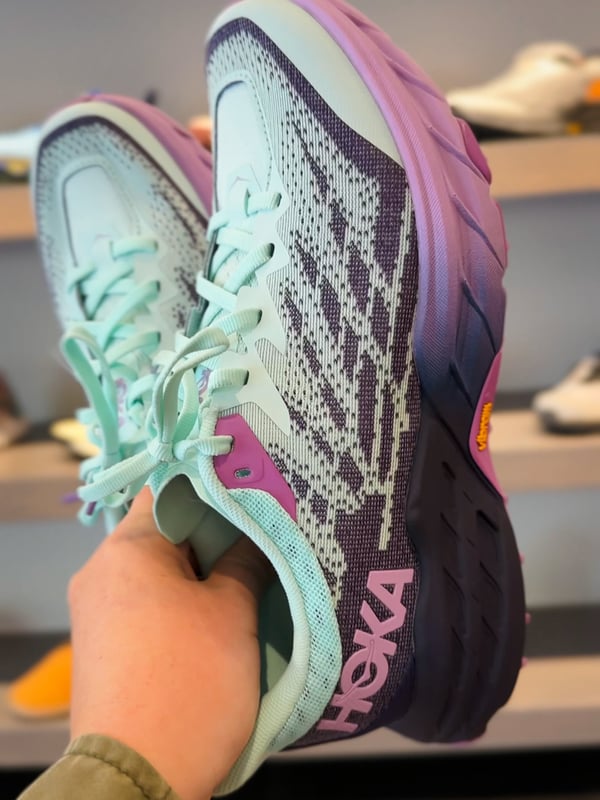 Closeup of Hoka trail runners at a Kintec store.
