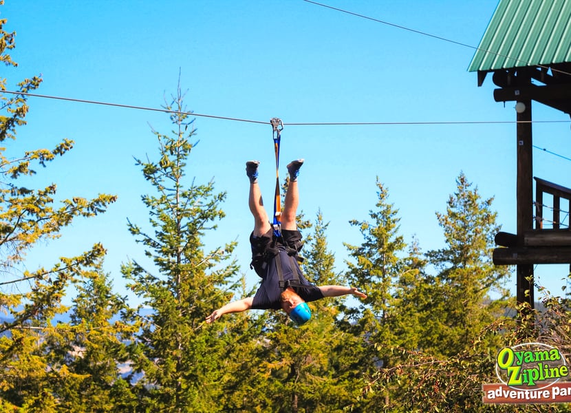 Man ziplines upside-down at Oyama Ziplines.