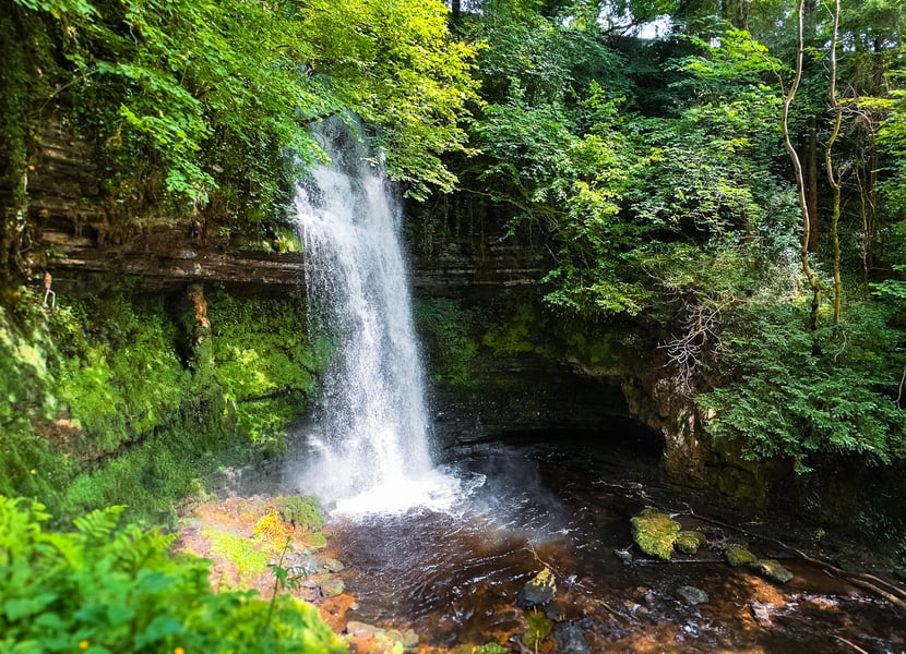 A beautiful waterfall surrounded by lush greenery. 