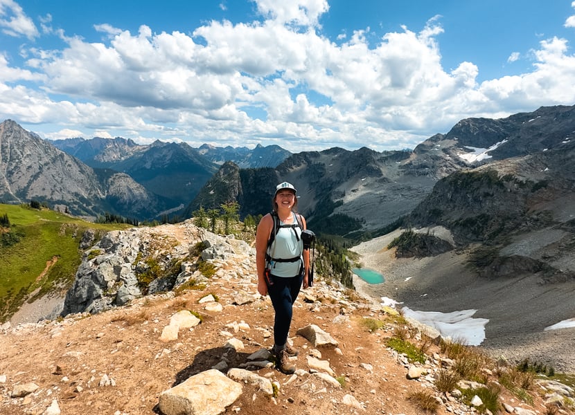 Woman stands on the top of a mountain in the North Cascades.