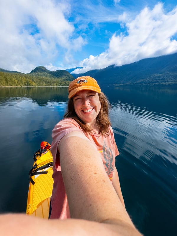 Selfie of a woman smiling while paddleboarding on a sunny day