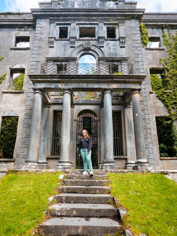Woman standing in front of an old manor house.