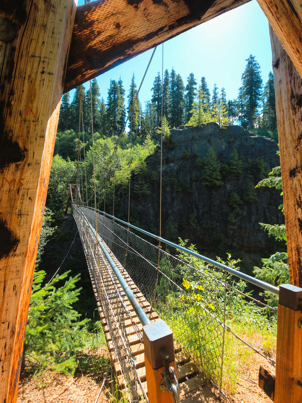 Close-up view of the Lava Canyon Suspension Bridge stretching over a deep volcanic gorge near Mount St. Helens