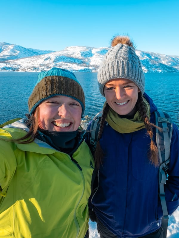 Selfie of two women on a cold, snowy day in front of Okanagan lake.