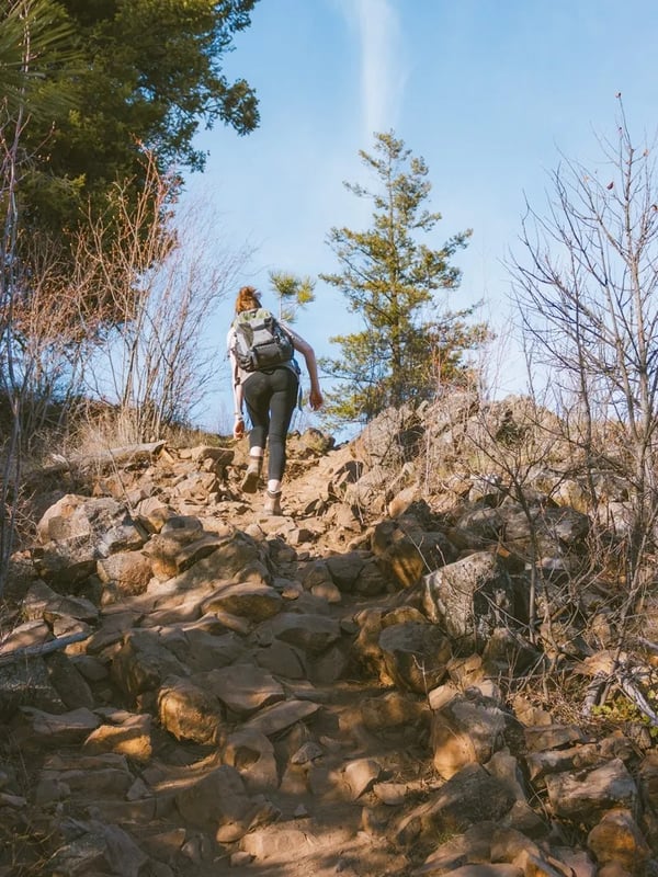 Woman climbing over rocks.