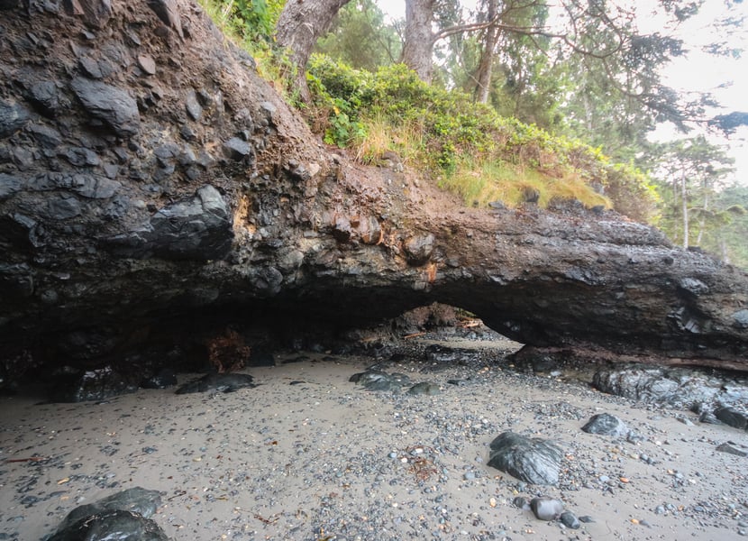 Rocky caves at the north end of Mystic Beach, with the ocean in the background and rocks scattered along the shore.