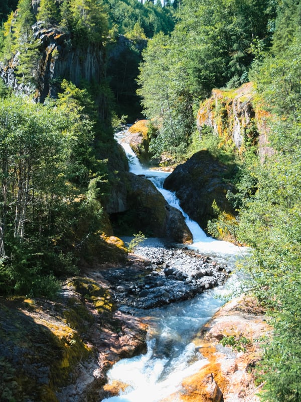 Waterfall rushing through narrow volcanic rock formations in Lava Canyon near Mount St. Helens