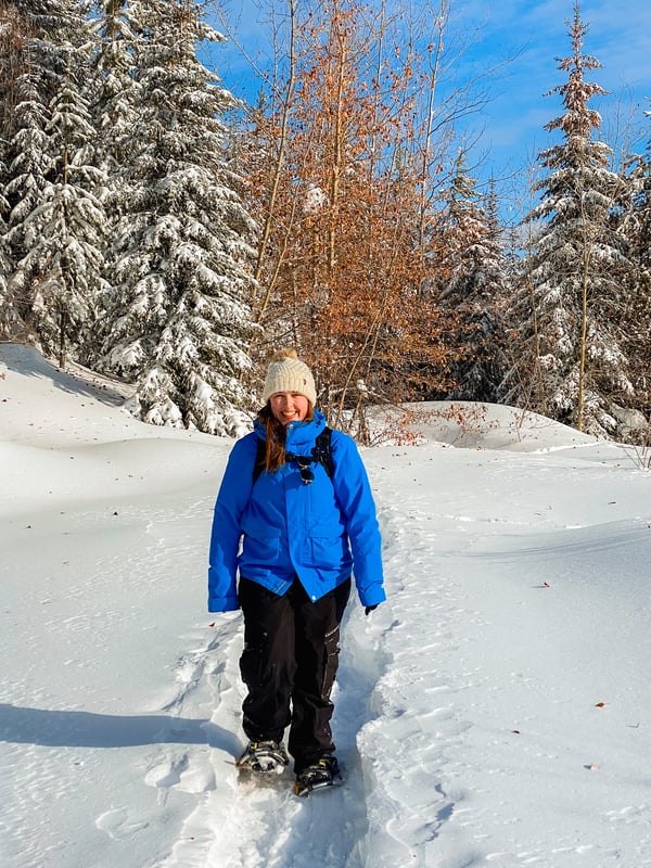 A woman snowshoeing on a sunny day in Kelowna.