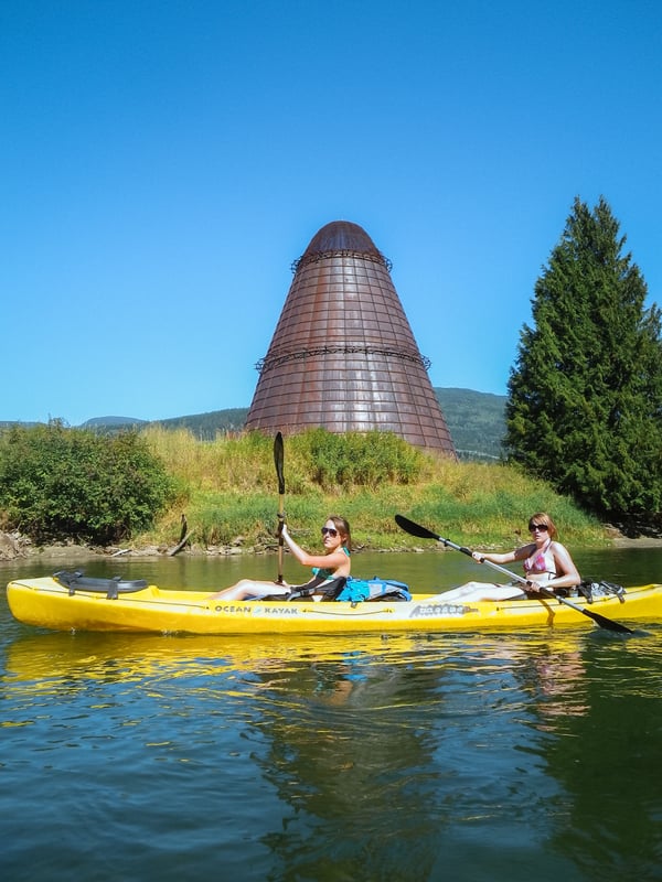 Two women kayaking on the Enderby River on a sunny day.