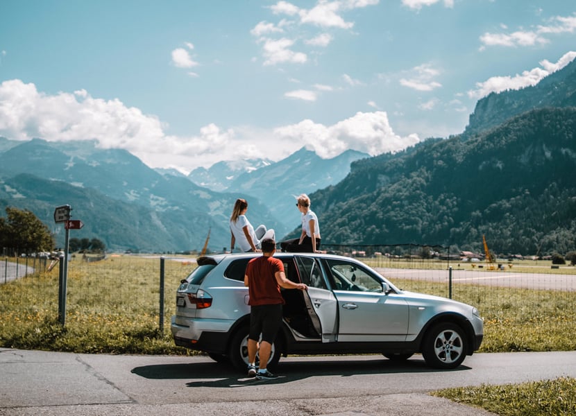 Group of friends relaxing on the side of the road while road tripping.