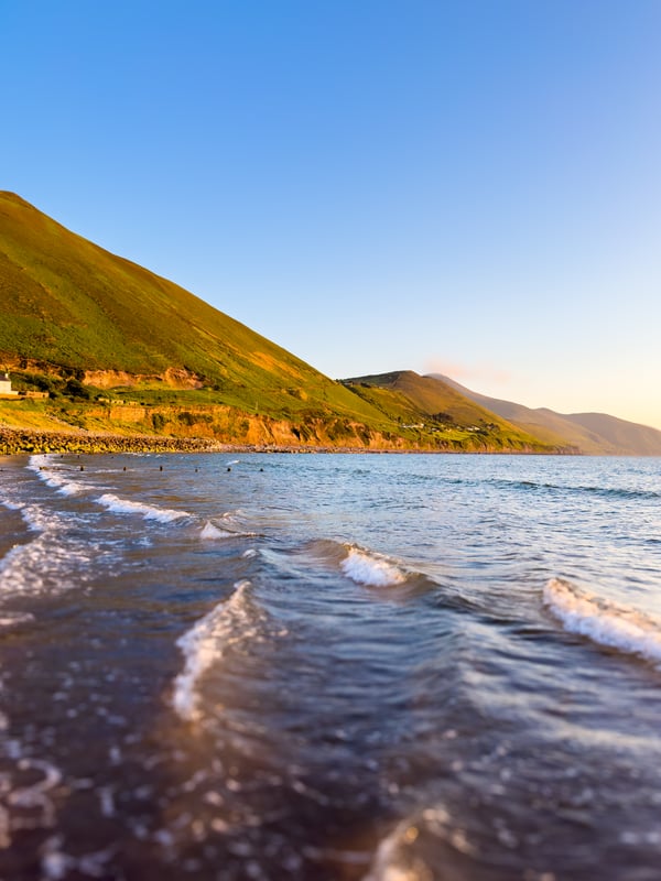 An ocean and hills at sunset at Rossbeigh Strand, a lovely hidden gem.