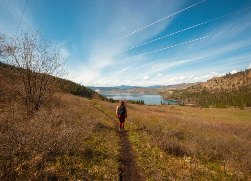Women hikes on a trail in Kal Lake on a sunny day