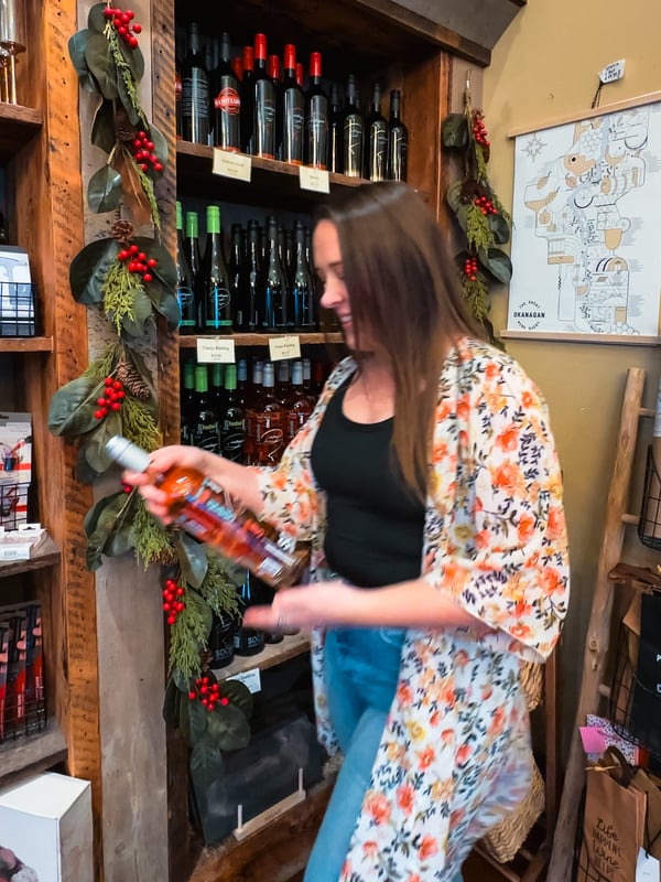 Woman picks up a wine bottle and walks away
