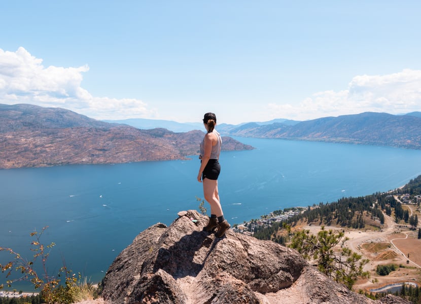 Women standing on a rock at the top of Pincushion Mountain overlooking Okanagan Lake.