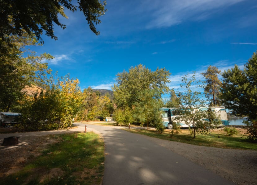 Campsites with an RV at Bear Creek Provincial Park in the Okanagan. Sunny day with a deep blue sky.