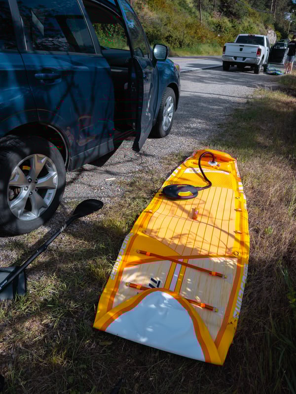 Inflating a paddleboard on the side of the road
