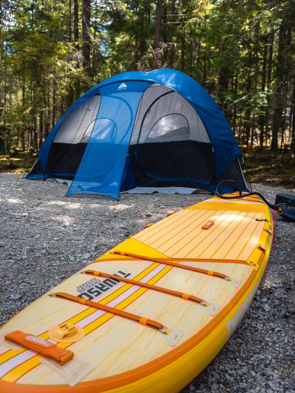 Paddleboard being inflated in a campground with an electric pump