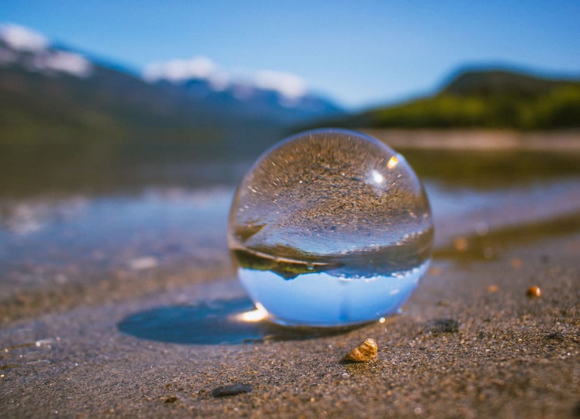Glass ball in the sand. Image reflected in ball is upside down.