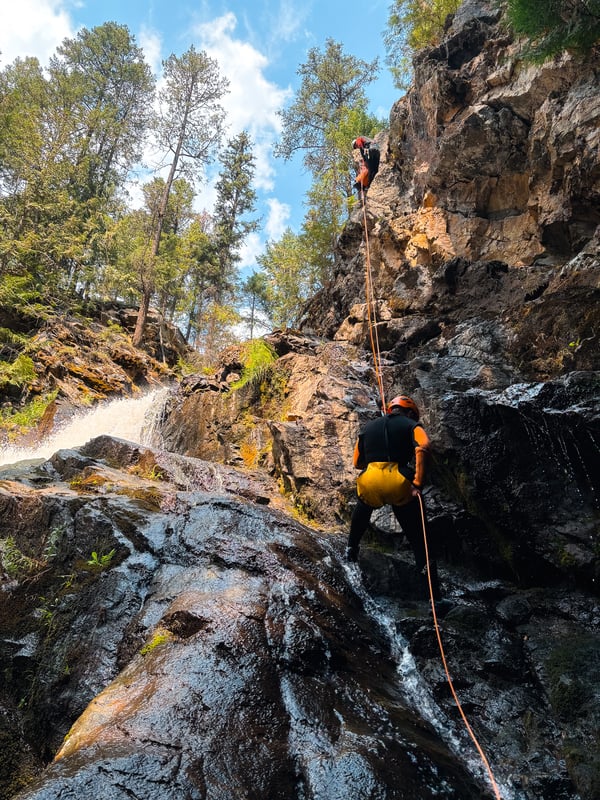 Person rappelling down a waterfall in Kelowna. 