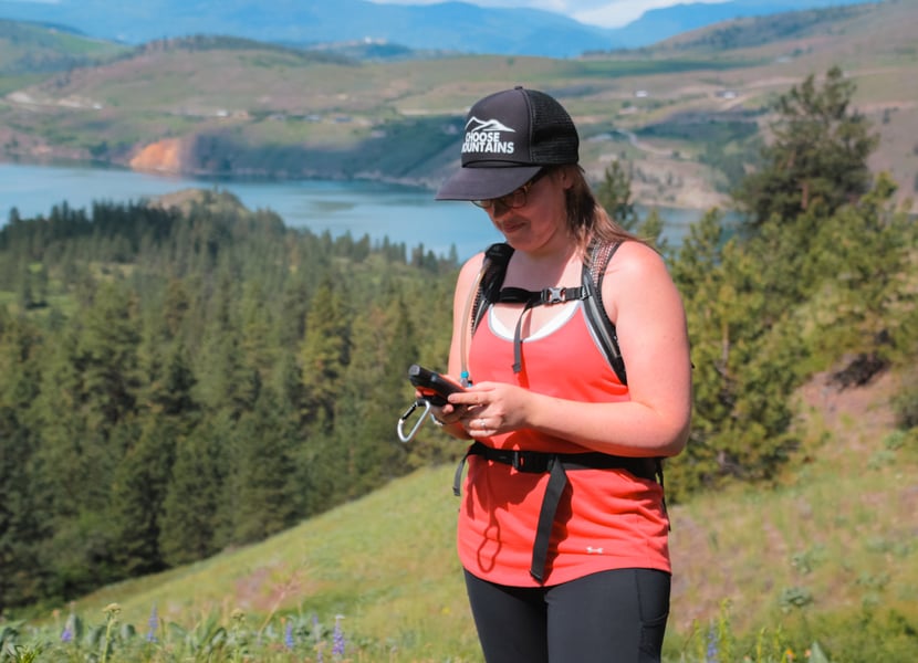 Women uses the Garmin Inreach Explorer at Kal Lake in Vernon