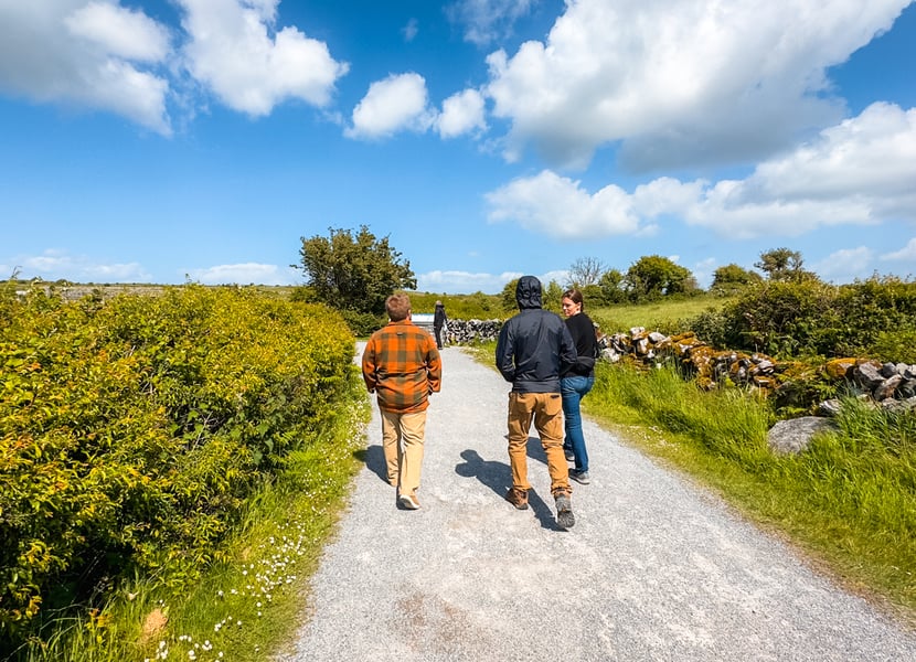 People walking on the gravel path to the Poulnabrone Dolmen.