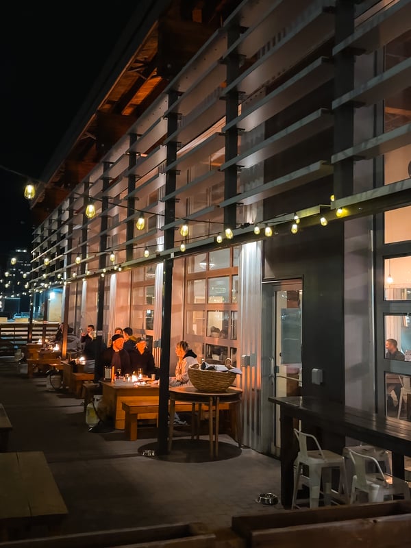 Outdoor dining with a fire pit and fairy lights