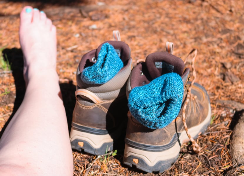 Woman lets her socks air out on a hike.