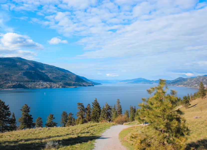 A gravel trail and forest with wiew of Okanagan Lake on Paul's Tomb hike near downtown Kelowna