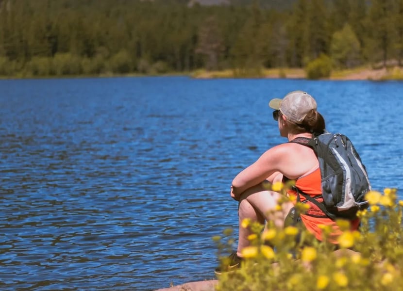 Woman sits on the edge of a large lake