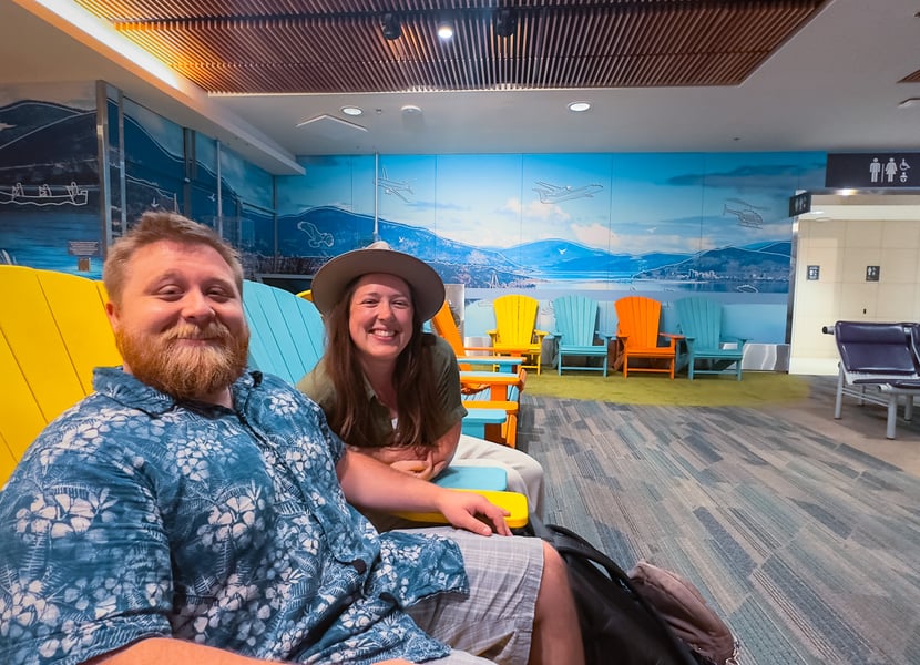 Two people sitting inside the airport terminal at YLW in Kelowna, BC