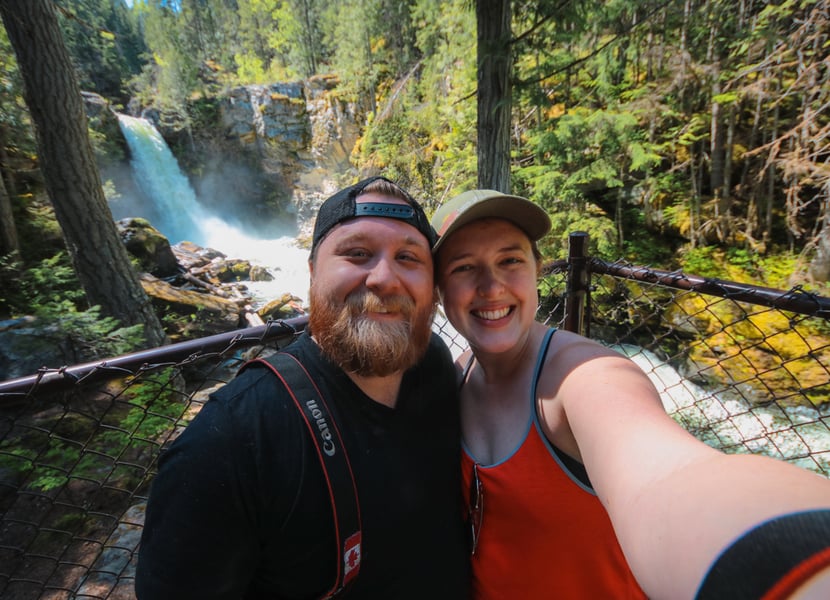 Selfie of a man and woman in front of Sutherland Falls in Revelstoke, BC.