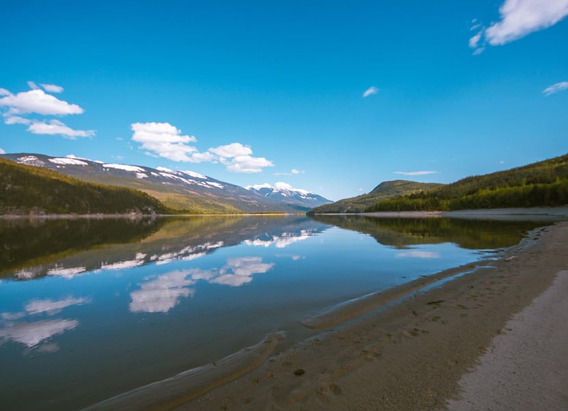 Sandy beach at Blanket Creek Provincial Park. Mirror like water on Arrow Lake.