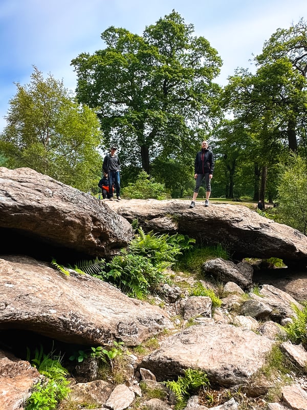 Three people standing on rocks.