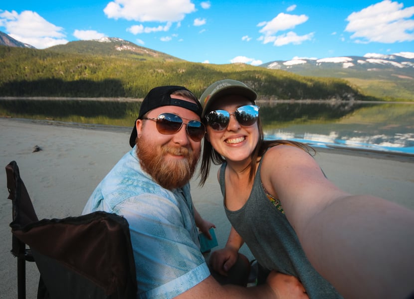 Selfie of a man and woman on a large sandy beach on Arrow lake at Blanket Creek Provincial Park in BC