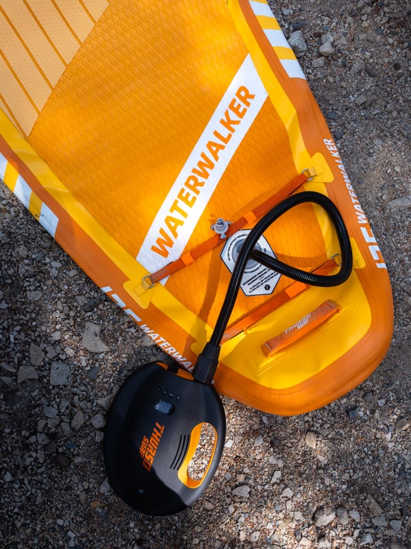 Above view of a paddleboard being inflated with an electric pump