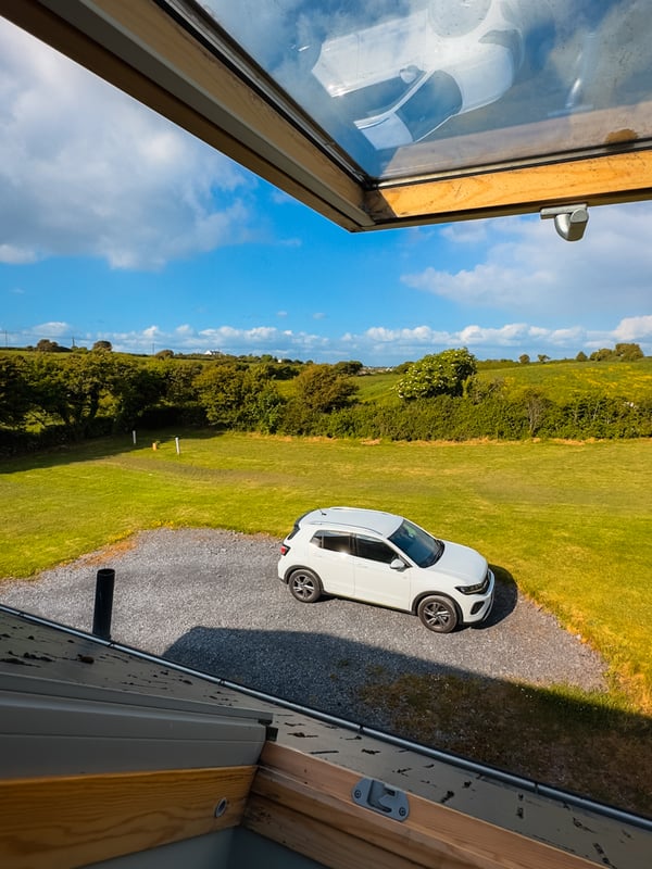 View of a rental car through the upper window of an Airbnb.