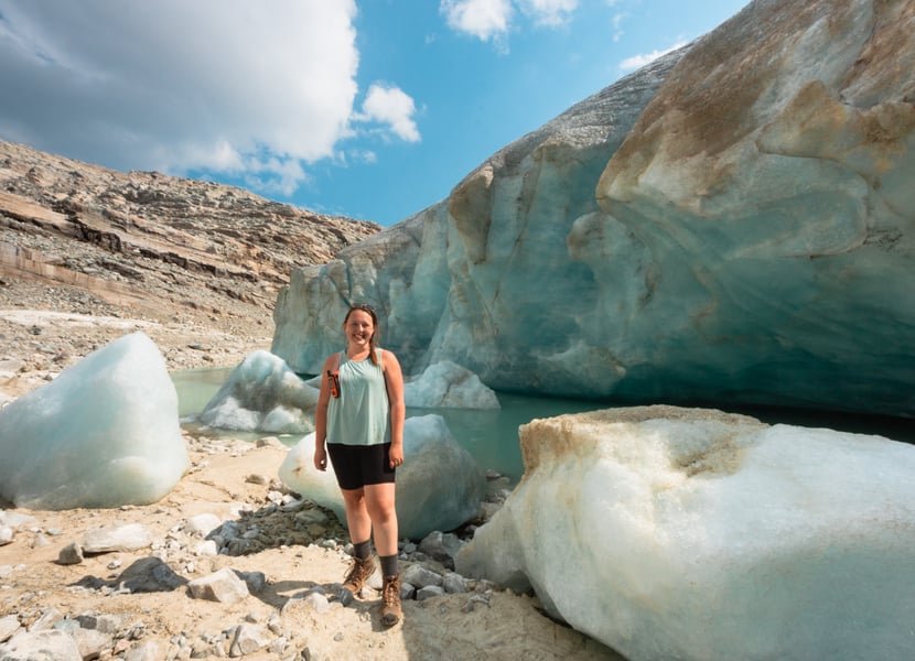 Woman stands in front of a glacial lake at Perley Rock in BC.