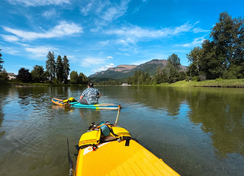 A couple floating on two floaties on the Enderby River.