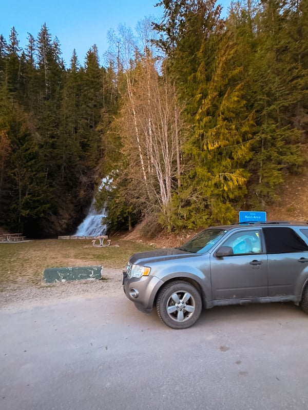 SUV in a rest stop with Ione Falls in the background.