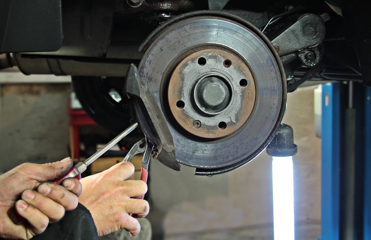 mobile mechanic replacing brake pads
