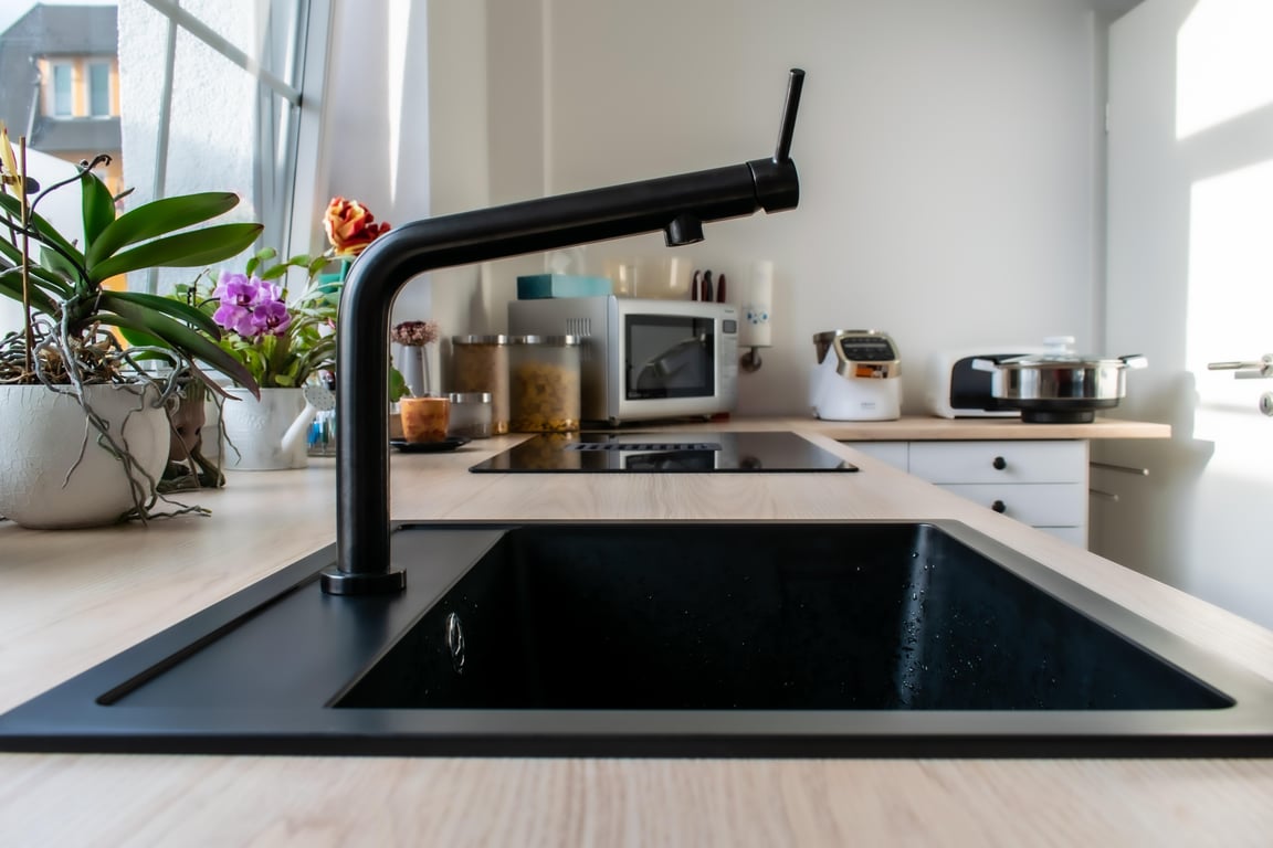 plumber repairing kitchen sink leak