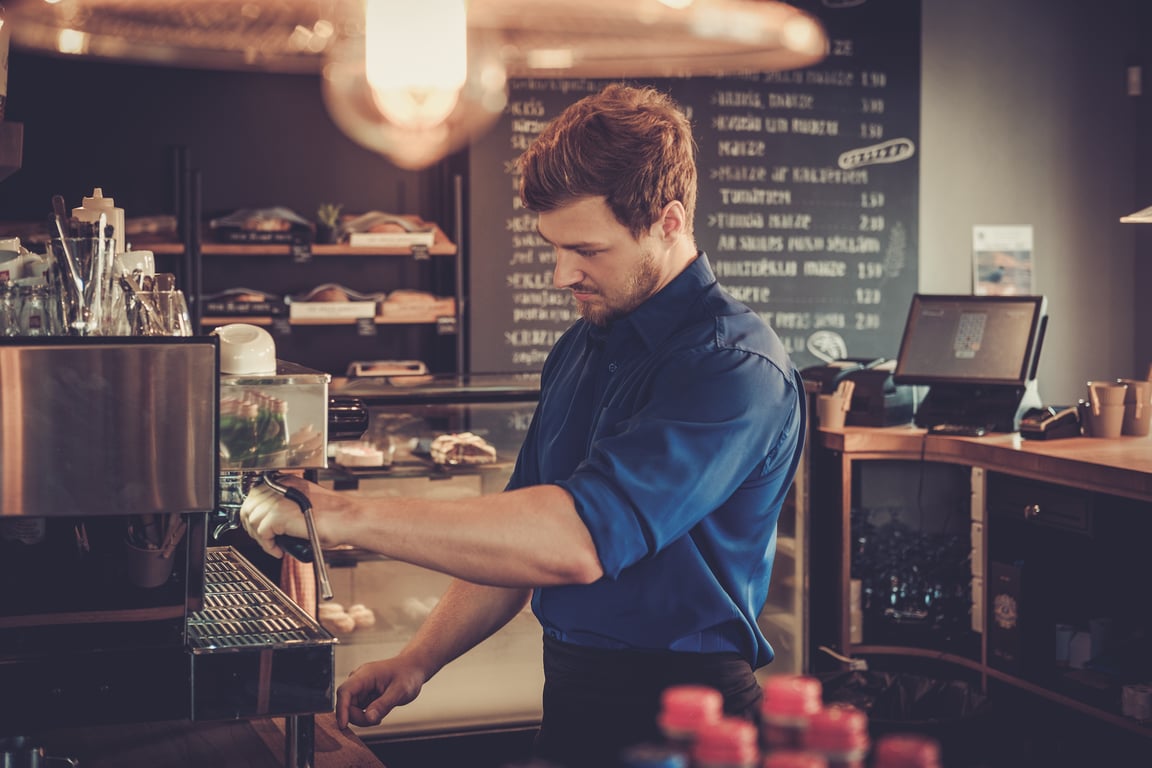 Barista worker using a commercial coffee making machine